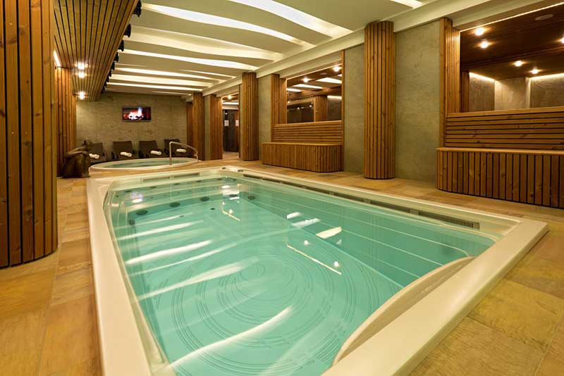Ein USSPA-Schwimmbad für den Innenbereich ist in einem Wellnessbereich mit separatem Entspannungsbereich installiert.