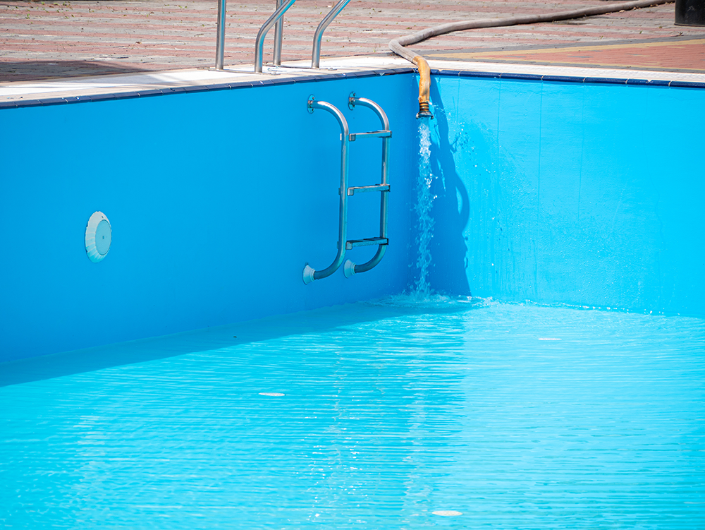 Wasser wird in ein Freibad gefüllt