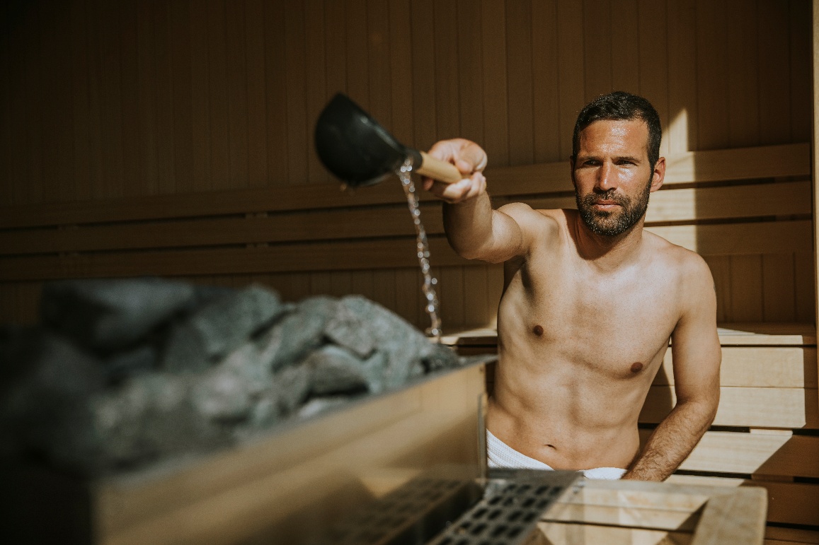 Wasser auf Saunasteine gießen