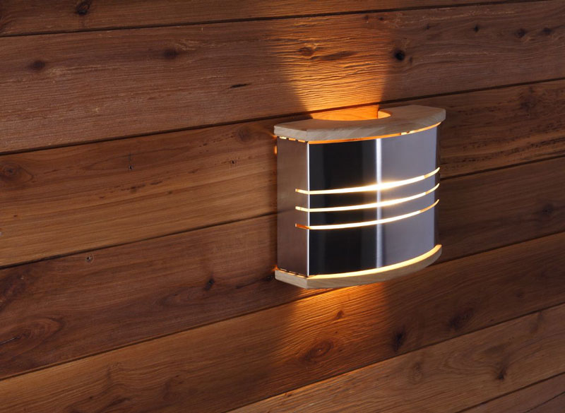 Wandmontierte Saunalampe aus Metall und Holz an der Saunawand.